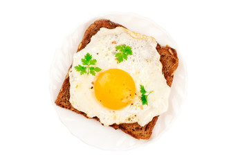 An egg cooked sunny side up on a toast, isolated on a white background with a clipping path