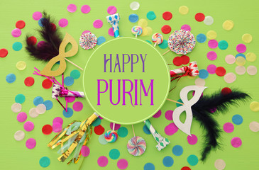 Purim celebration concept (jewish carnival holiday) over green wooden background. Top view.