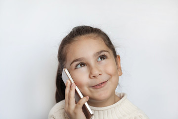 Portrait of a smiling cute girl holding smartphone over white background