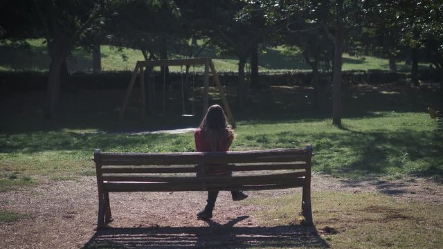 lonely sad woman sitting on bench in the park,thinking her abortion