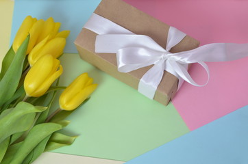 Fresh beautiful yellow tulips gift box on colorful background. Spring concept. top view with copy space. Happy mother day, hello spring, 8 march women day