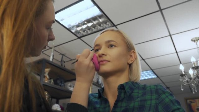 Makeup artist at work. Female visagist using brow brush. Makeup tips from professionals.