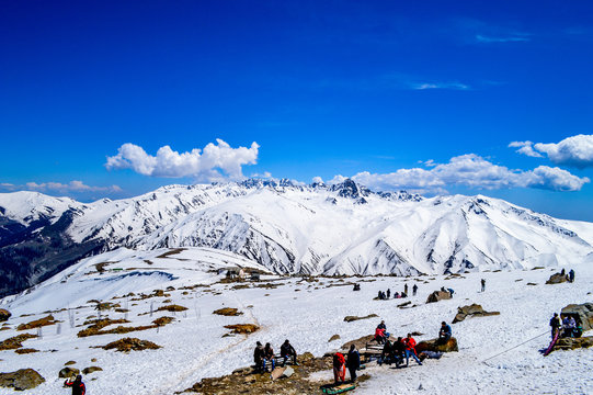 Scenic view of snow covered mountains with cloudy blue sky.