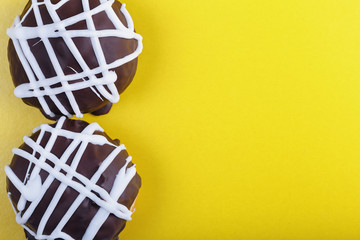 two fresh delicious chocolate donuts on a colored background as a grocery background