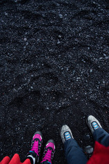Couple standing on the Black sand Reynisfjara Beach in Iceland