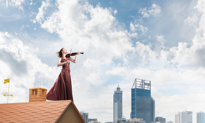 Woman violinist in red dress playing melody against cloudy sky. Mixed media © adam121
