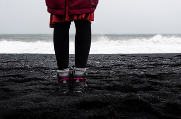 Woman walking on the Black sand Reynisfjara Beach in Iceland
