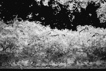 Snow flakes on a window pane black and white closeup photo