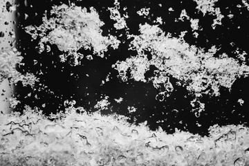 Snow on a window pane black and white closeup photo