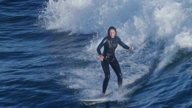 Happy Surfer Rides A Wave, She Holds Up Peace Signs And Smiles Before Jumping Off Her Board (Slow Motion)