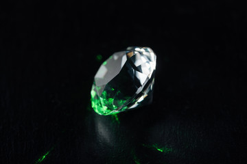 illuminated diamond with green light on black background