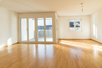 bright new living room in an empty apartment with french doors and parquet wooden floors