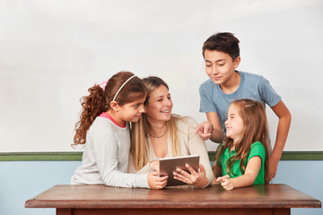 Kinder und Lehrerin zusammen am Tablet