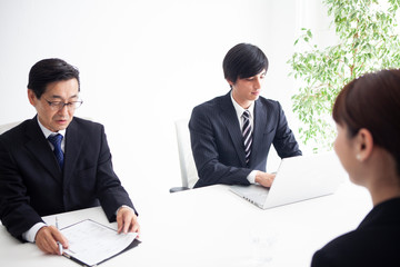 面接を受ける女性と質問を行う男性面接官二人