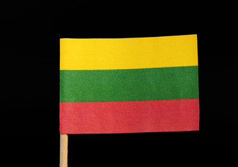 A tricolour national flag of Lithuania on toothpick on black background. A horizontal triband of yellow, green and red