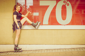Woman wearing roller skates next to sale