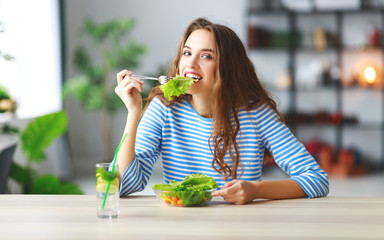 healthy eating. happy young girl eating salad in  morning in kitchen