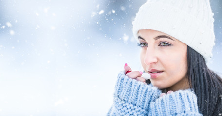 Attractive young woman l protecting lips with lip balm in snowy and frozen weather - obrazy, fototapety, plakaty