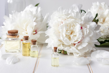 A bottle of peony essential oil with fresh peony flowers © Madeleine Steinbach