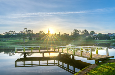Sunrise on the small bridge overlooking the lake with the dramatic sky welcomes new day in the tourist city of Vietnam