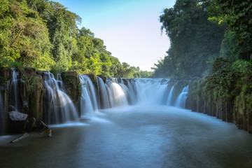Fototapeta na wymiar Beautiful large waterfall in the forest. Landscape of rainforest abundant natural resources in Thailand.
