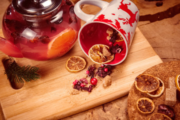 composition teapot with tea, a mug with a deer, dried oranges, berries