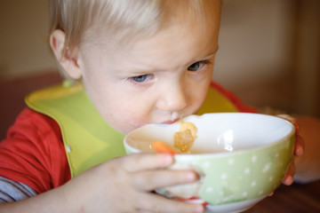 Little boy drinking independently from a bowl