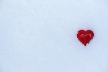 one red heart in the snow on Valentine's Day.  close-up, background image