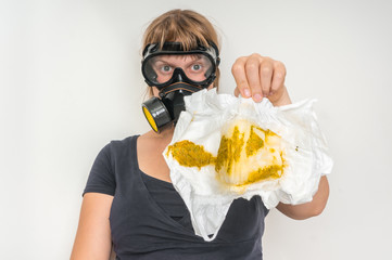 Mother with gas mask changing smelly diaper