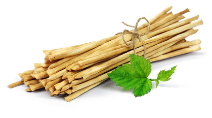 Crispy crunchy long bread sticks  grissini with green leaf, isolated on a white background.