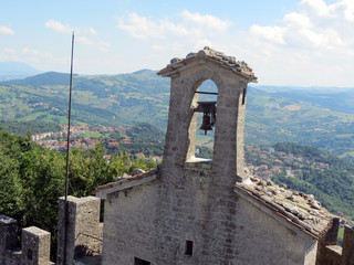 The bell on the church and the slope of Mount Monte  Titano, Republic of San Marino, Italy