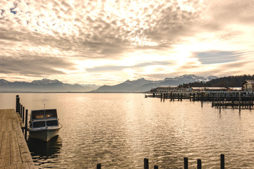 Steg am Chiemsee mit Sonnenuntergang und Bergen