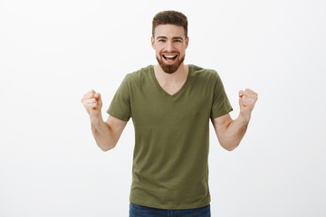 Come on you can do it. Active and excited happy handsome man with beard clench fists in cheer, being supportive encouraging friend, watching team scoring goal, celebrating victory, triumphing