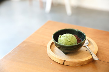 Japanese green tea ice cream with red bean topping on wooden table in coffee shop