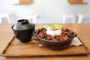 Steak tuna on rice with egg Japanese style on wooden table