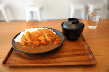 Curry rice with fried pork tonkatsu Japanese food on wooden table