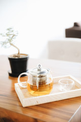 Hot teacup with teapot beverage on wooden table