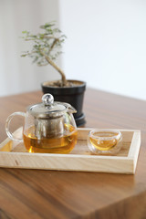 Hot teacup with teapot beverage on wooden table