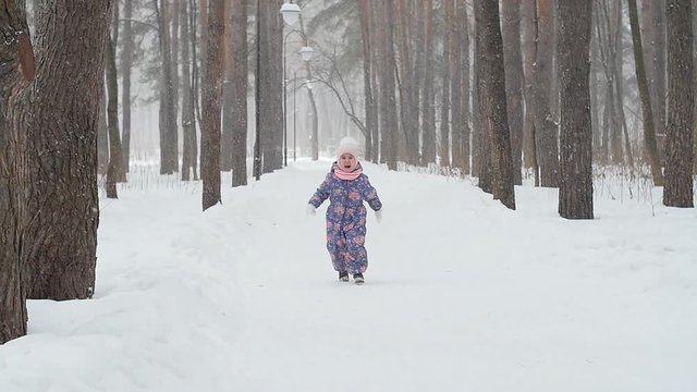 Winter and Christmas concept. Happy little girl running in a winter park