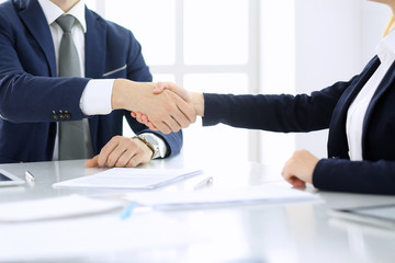Group of business people or lawyers shaking hands finishing up a meeting , close-up. Success at negotiation and handshake concepts