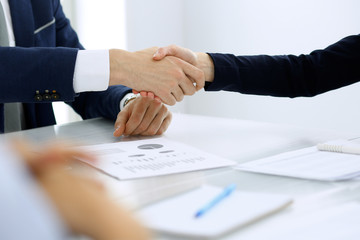 Group of business people or lawyers shaking hands finishing up a meeting , close-up. Success at negotiation and handshake concepts