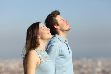 Relaxed couple breathing fresh air with urban background