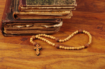 Old bible and crucifix on wooden table