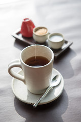 Hot tea served in a mug with milk and sugar