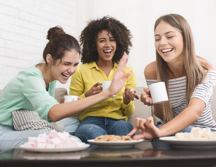 Diverse friends drinking coffee and eating cookies