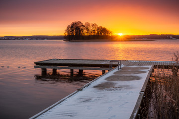 Sunrise over the Swiecajty lake and wooden footbridge near Wegorzewo, Masuria, Poland