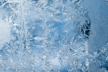 Frosty patterns on the frozen window are macro. Winter background