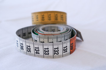 Due metri da sartoria, sfondo bianco, oggetti da cucito