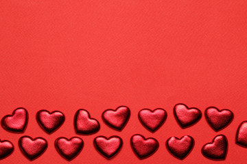 Red hearts on a bright red background. frame of hearts, top view with space for text