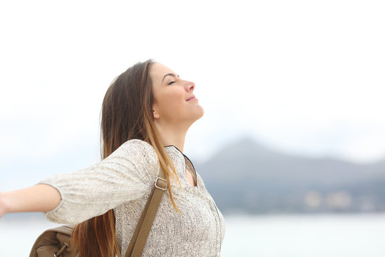 Happy woman breathing fresh air on the beach or lake